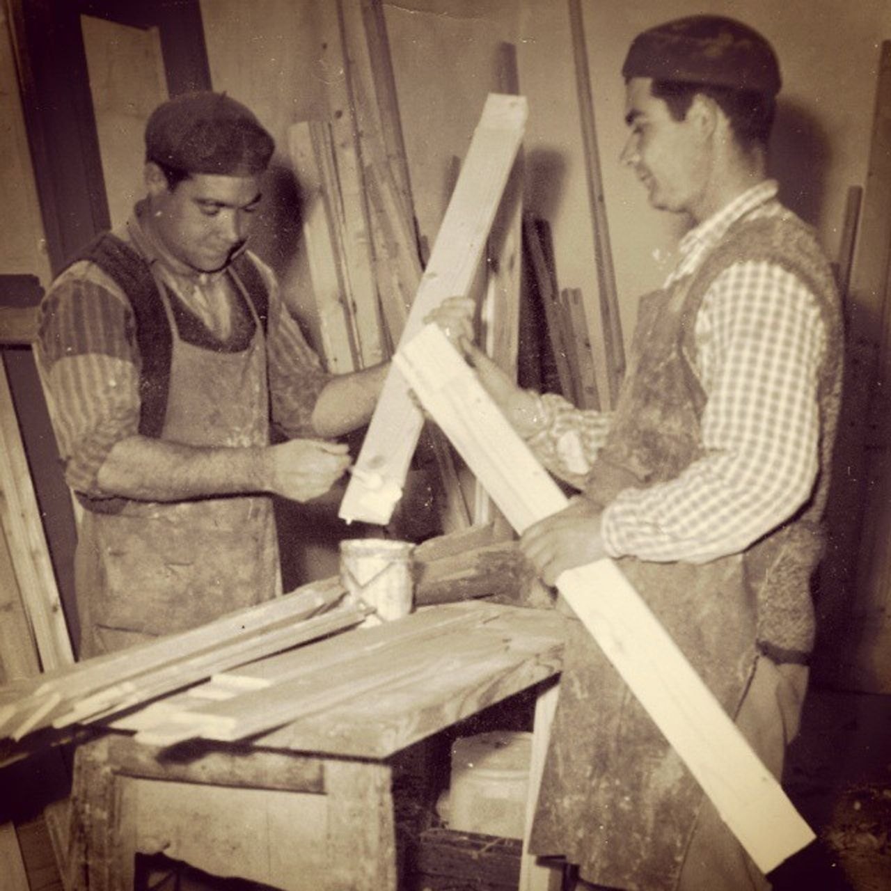 Foto storica della bottega: due falegnami al lavoro su listelli di legno